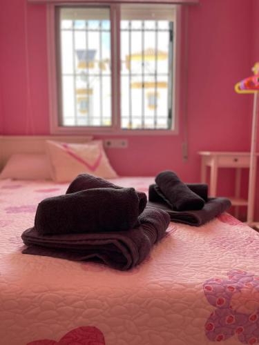 a bedroom with a bed with towels on it at Terrasol Chalet en Torre Del Mar in Torre del Mar