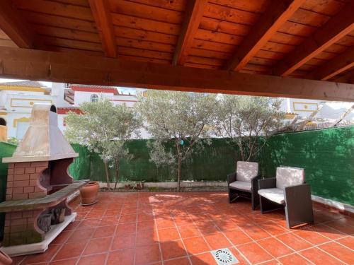 an outdoor patio with two chairs and a fireplace at Terrasol Chalet en Torre Del Mar in Torre del Mar