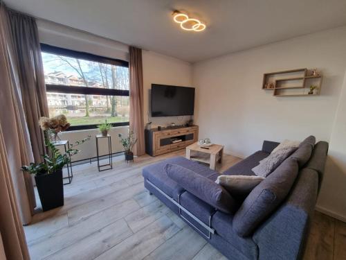 a living room with a couch and a flat screen tv at Hafenperle in Bad Zwischenahn
