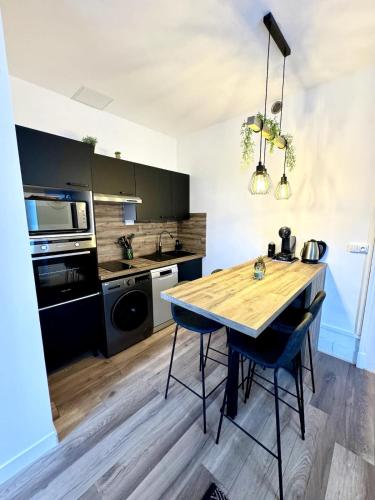 une cuisine avec une table en bois et des appareils électroménagers dans l'établissement Le Grand Port - T2 with parking, à Aix-les-Bains