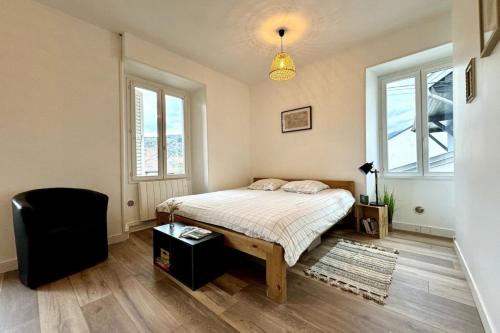 une chambre avec un lit, une chaise et des fenêtres dans l'établissement Le Grand Port - T2 with parking, à Aix-les-Bains