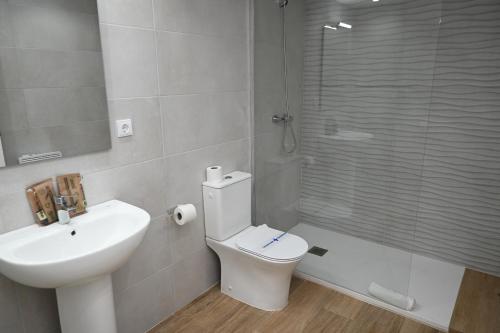 a bathroom with a toilet and a sink and a shower at Homenfun Dalt Badalona in Badalona