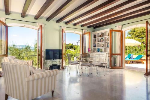 a living room with chairs and a television at La Belle Villa - Family Retreat Magnificent View in Akrotiri