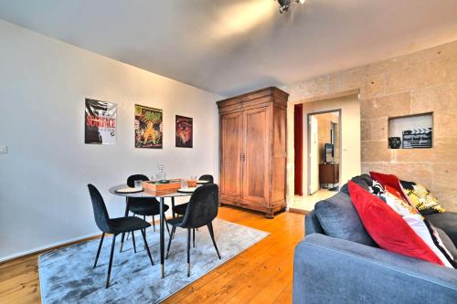 un salon avec un canapé bleu, une table et des chaises dans l'établissement Olympia - Terrasse, Parking gratuit, Thème Cinéma, Coeur de ville, Rez de chaussée, Fibre, Tv 4K, à Saintes