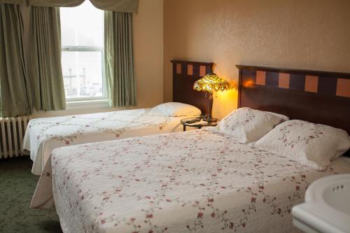 two beds in a hotel room with a window at Gilmore Hotel, Trademark Collection by Wyndham in Ketchikan
