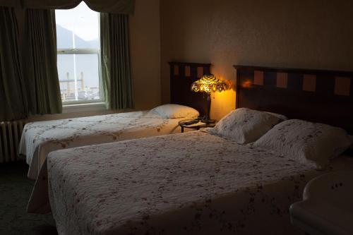 a hotel room with two beds and a window at Gilmore Hotel, Trademark Collection by Wyndham in Ketchikan