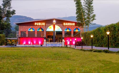 un ristorante-pizzeria con luci rosse in un campo di Publiq Darbar Tent House a Pune
