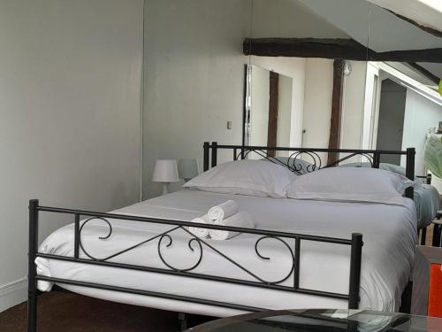 - une chambre dotée d'un lit avec un cadre en fer forgé dans l'établissement Le Singulier - Studio au coeur de Paris, à Paris