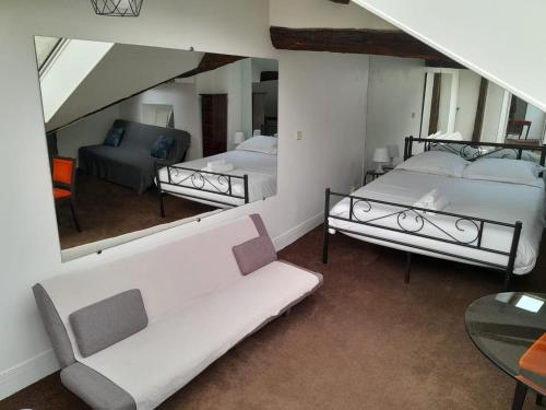 - un salon avec 2 lits et un miroir dans l'établissement Le Singulier - Studio au coeur de Paris, à Paris