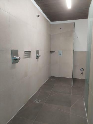 a bathroom with a shower and a tiled floor at Haus Obermaiselstein in Obermaiselstein