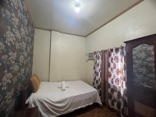a small room with a bed and a window at Fontelo Bungalow Guest House in Siquijor