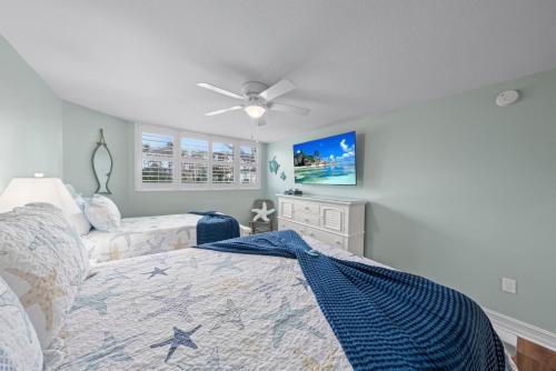 Un dormitorio con una cama y un ventilador de techo. en Pine Cove #101, en Sanibel