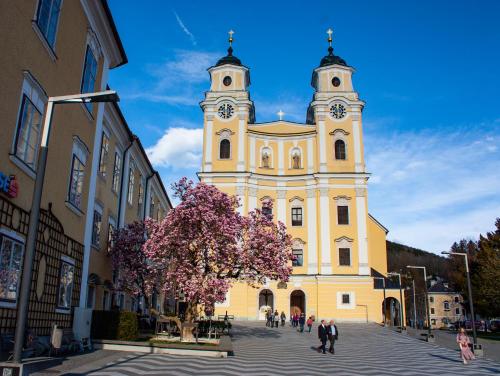 a large yellow building with a clock tower at Ferienwohnung Alpenseepark in Mondsee