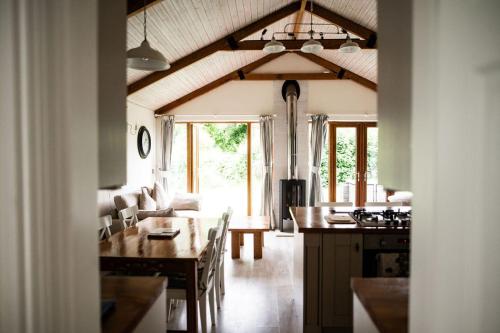 a kitchen and living room with a table and a dining room at The Anchorage & The Tackleshed in Llancarvan