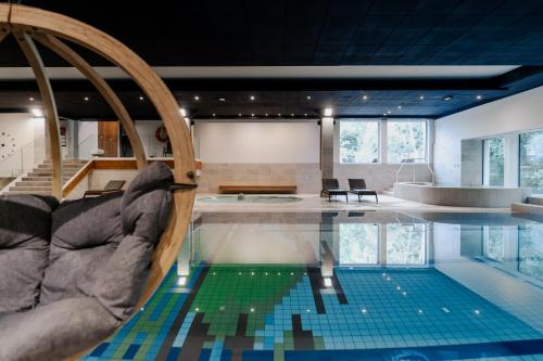 a room with a swimming pool with a table at Hotel Shuum Boutique - Destigo Hotels in Kołobrzeg