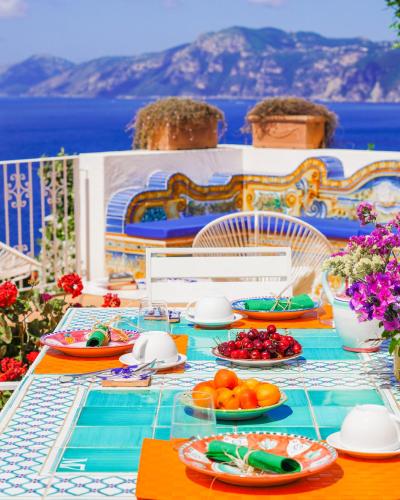 a table with plates of food on top of a balcony at Masa Villas in Praiano