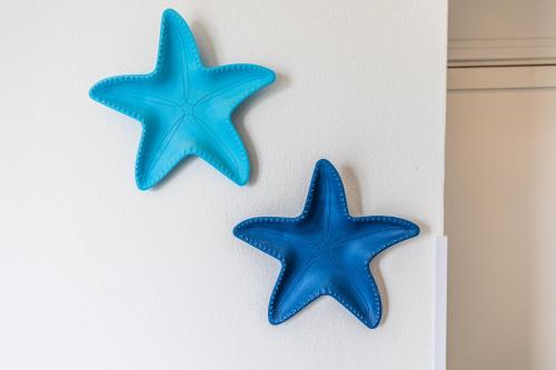 two blue starfish hanging on a wall at Villa Tre Mari in Villasimius