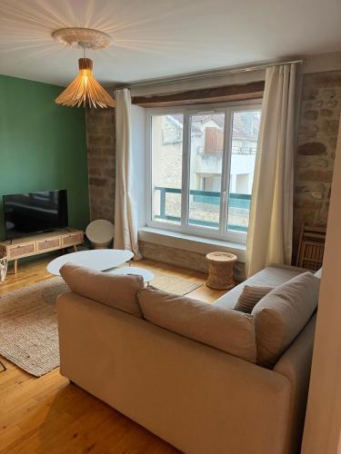 un salon avec un canapé et une grande fenêtre dans l'établissement Magnifique Duplex à Melun, à Melun