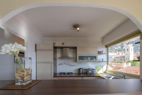 une cuisine avec une table et un vase de fleurs sur une table dans l'établissement Dina Palace, à Villefranche-sur-Mer