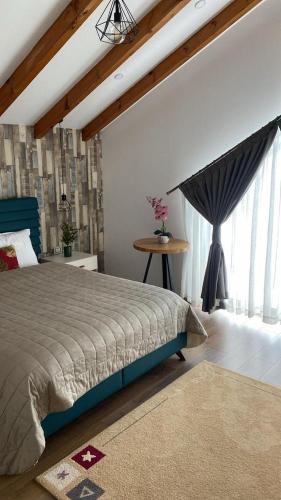 a bedroom with a bed and a table and a window at Hotel Vila Aleksander 2 in Korçë