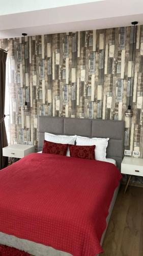 a bedroom with a red bed with a red blanket at Hotel Vila Aleksander 2 in Korçë