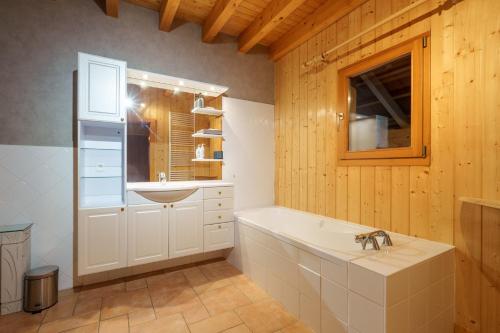 a bathroom with a bath tub and a sink at Chalet La Rayée - Vue lac et montagne 14p in Gérardmer