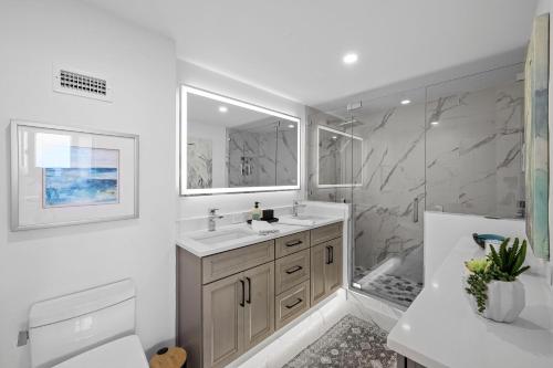 a white bathroom with a sink and a shower at Beachfront condo with views of beach and spacious pool in Marco Island