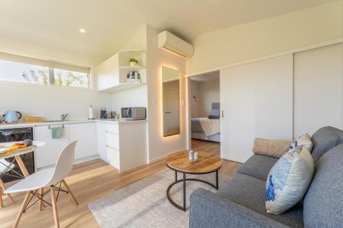 a living room with a couch and a table at Palm Springs Pearl - 7 minutes walk to the beach in Papamoa