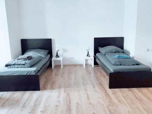 two beds in a room with wooden floors at Nice Apartment in Solingen in Solingen