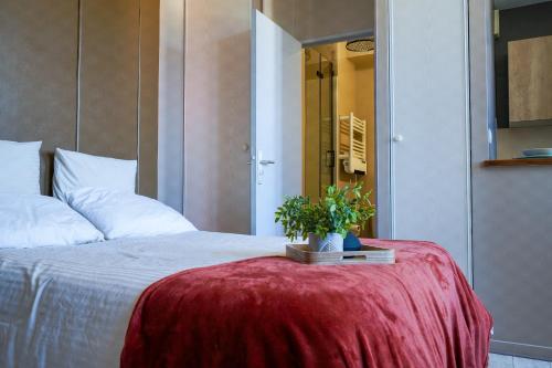 リモージュにあるAppartement style hôtel cocooningのベッドルーム1室(テーブルに鉢植えの植物が置かれたベッド1台付)
