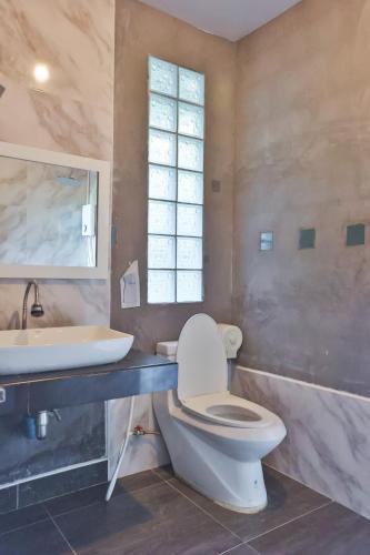 a bathroom with a toilet and a sink at Judy Park & Resort Buriram in Buriram