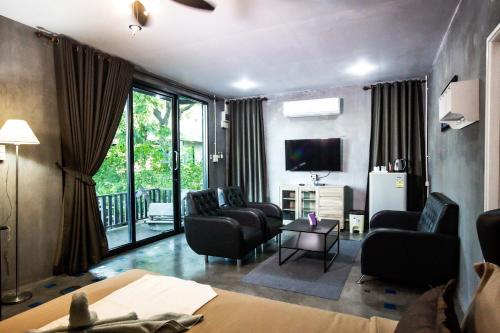 a living room with a couch chairs and a television at Judy Park & Resort Buriram in Ban Nong Hua Wua