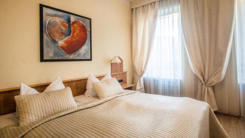a bedroom with a bed with a heart painting on the wall at Hotel Löhr in Baden-Baden