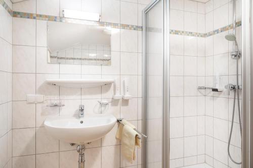 Un baño blanco con lavabo y ducha. en Obersteffengut, en Wagrain