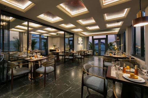 a restaurant with tables and chairs and windows at HOTEL de LAGOM in Hanoi
