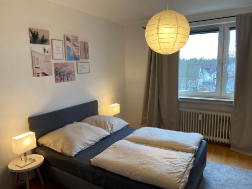 a bedroom with a bed with a lamp and a window at Perfekt für 1, 2 und bis zu 6 Personen - Nah am Flughafen, Frankfurt City, Wiesbaden und Rüsselsheim in Mörfelden-Walldorf