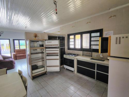 a kitchen with a refrigerator and a counter top at Casa de Praia - Pe na Areia in Mongaguá