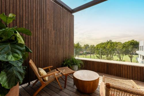 a patio with a table and chairs on a balcony at Kimpton Aysla Mallorca by IHG in Santa Ponsa