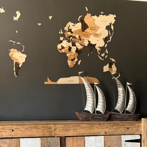 a world map on a wall with three sail boats on a wooden table at Simba Safaris African Pride Exotic Lodge in Lephalale