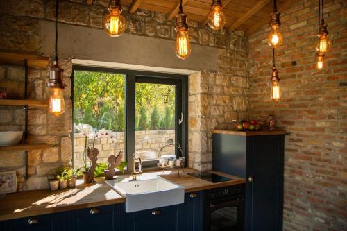 eine Küche mit einem Waschbecken, einem Fenster und Lichtern in der Unterkunft Villa Dolce Vita - Vintage in Warna