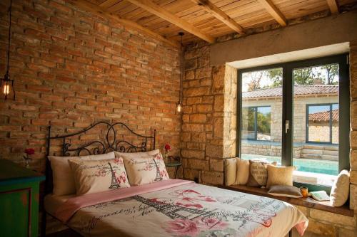 ein Schlafzimmer mit einem Bett und einer Ziegelwand in der Unterkunft Villa Dolce Vita - Vintage in Warna