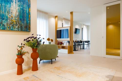 a living room with vases of flowers and a chair at Hera Rooms and Suites in Agrigento