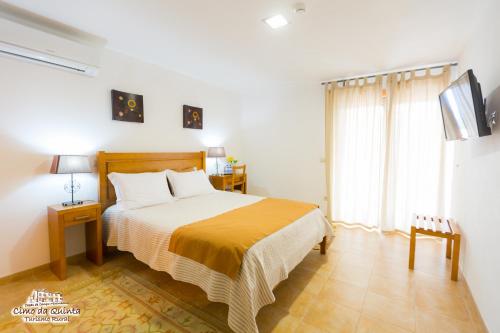 a bedroom with a bed and a large window at Casas Campo Cimo da Quinta in Miranda do Douro