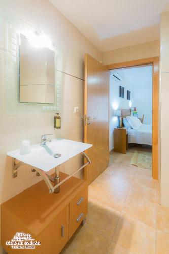 a bathroom with a sink and a bedroom at Casas Campo Cimo da Quinta in Miranda do Douro