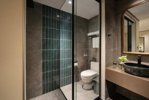 a bathroom with a toilet and a sink and a mirror at HOTEL de LAGOM in Hanoi