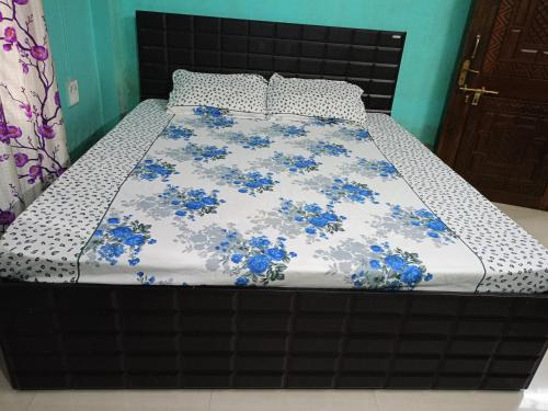 a bed with blue flowers on it in a bedroom at Comfort Inn Homestay in Guwahati