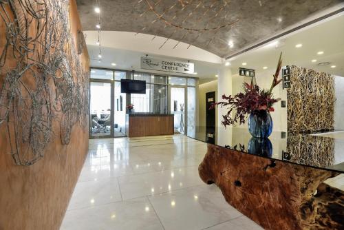 a lobby with a vase of flowers on a counter at The Leonardo in Johannesburg
