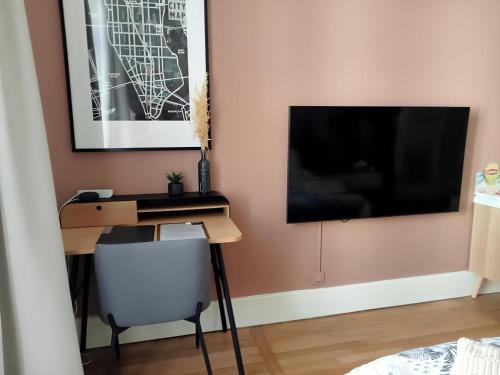 a room with a desk and a television on a wall at Nancy Gare Centre Parking in Nancy