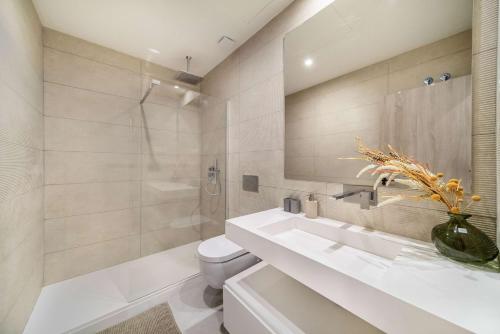 a bathroom with a sink and a toilet and a mirror at Casa Sol Luxury Rooftop Penthouse Gym Spa Pools in Marbella