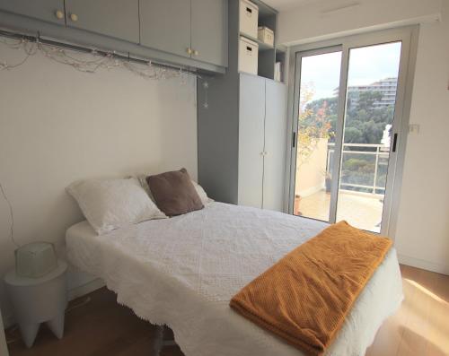 une chambre avec un lit et une grande fenêtre dans l'établissement Happyfew la terrasse de Selfina, à Nice